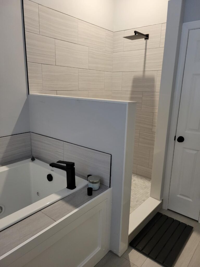 Finished bathroom remodel with a soaking tub and black faucet
